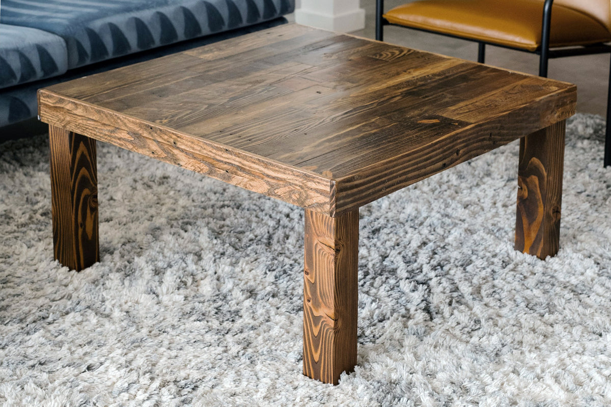 This handcrafted, square coffee table showcases enduring quality with its natural finish and rustic design, crafted from reclaimed wood. Ideal as a reclaimed wood furniture accent for living rooms or lounge seating areas.