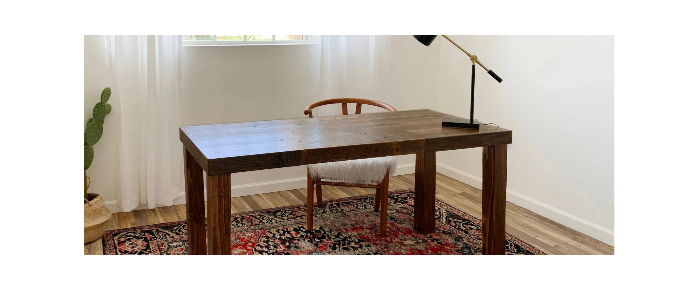 photo of a reclaimed wood desk in a clean, modern room with white walls, flowy white curtains and a stylish chair