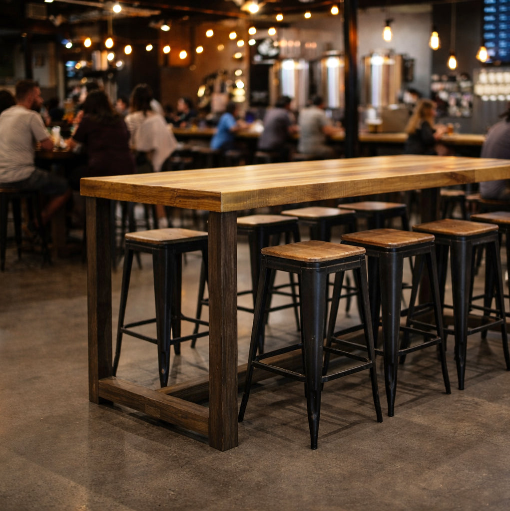 A handcrafted reclaimed wood bar-height table with durable metal stools anchors this inviting, warmly lit bar space. Perfect as a restaurant table or kitchen island, it highlights sustainable Arizona craftsmanship and enduring quality.