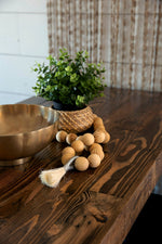 Provincial finish reclaimed wood table top with wood beads and a plant