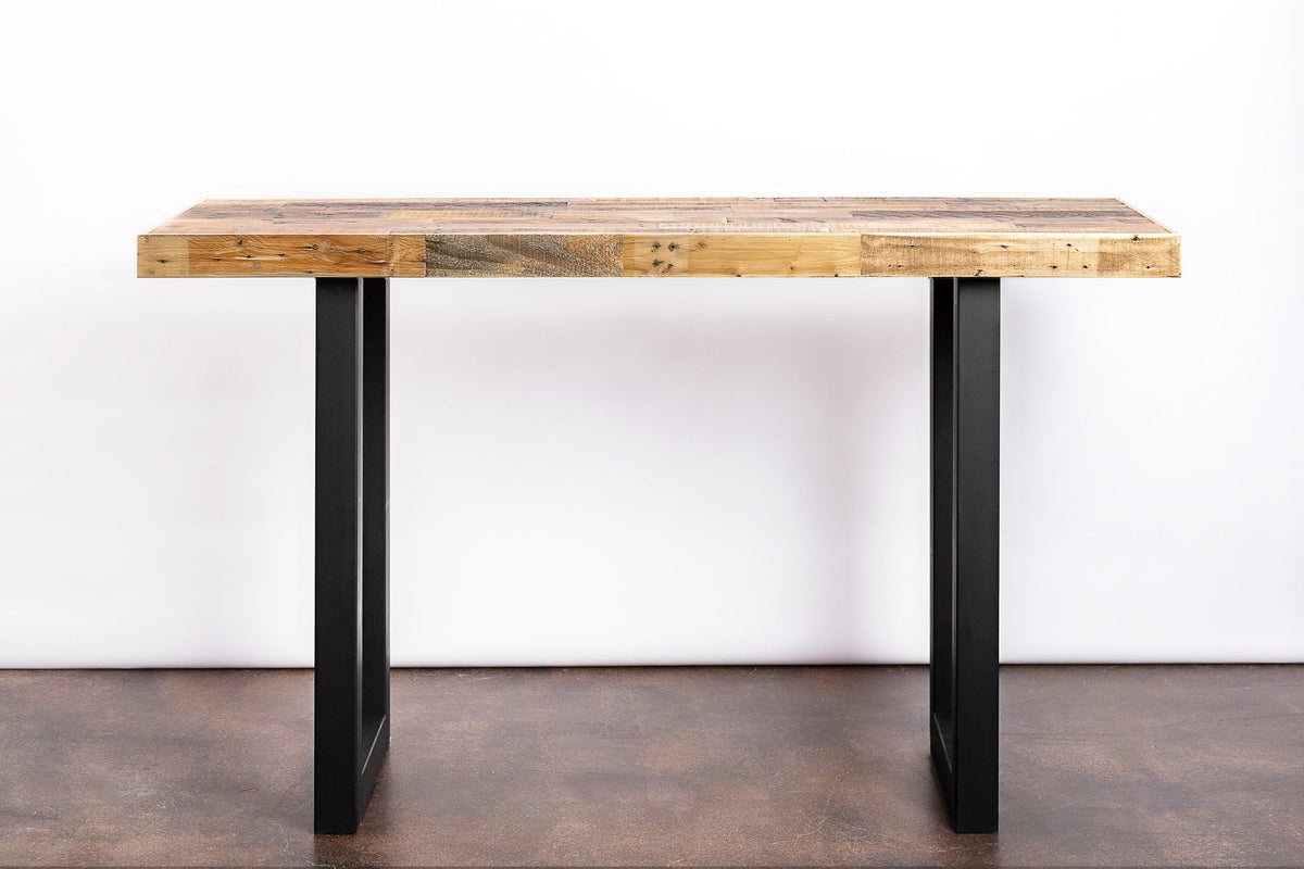 Handcrafted in Arizona, this Gunnison bar-height table showcases a robust reclaimed wood top with a warm light brown finish and durable black steel legs. Ideal as a narrow kitchen island, dining table, or restaurant table.