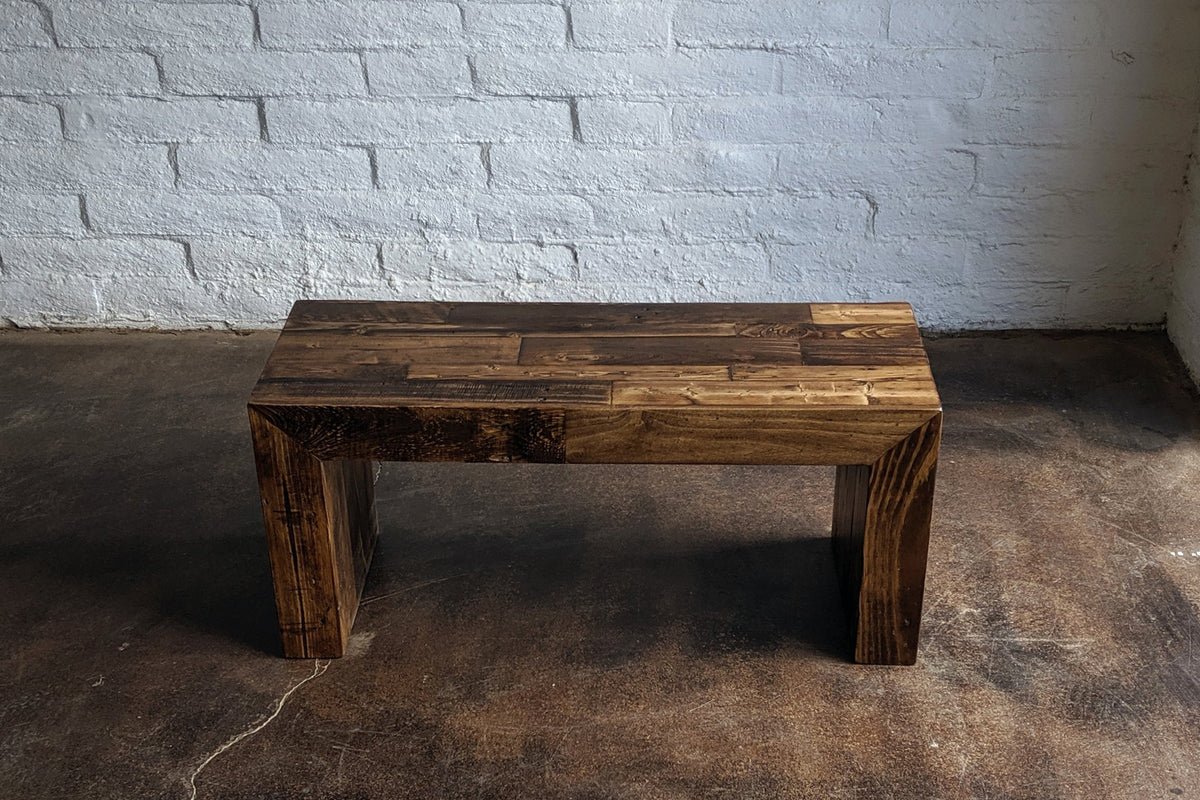 This handcrafted, rectangular reclaimed wood bench showcases a rustic finish and minimalist design. This sustainable reclaimed wood furniture highlights timeless Arizona craftsmanship.