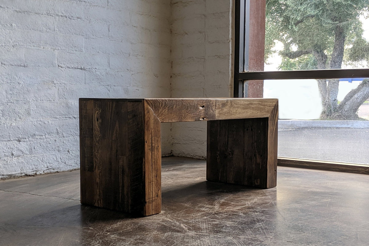 This handcrafted reclaimed wood bench features sturdy, thick legs and a rustic finish, showcasing sustainable craftsmanship.